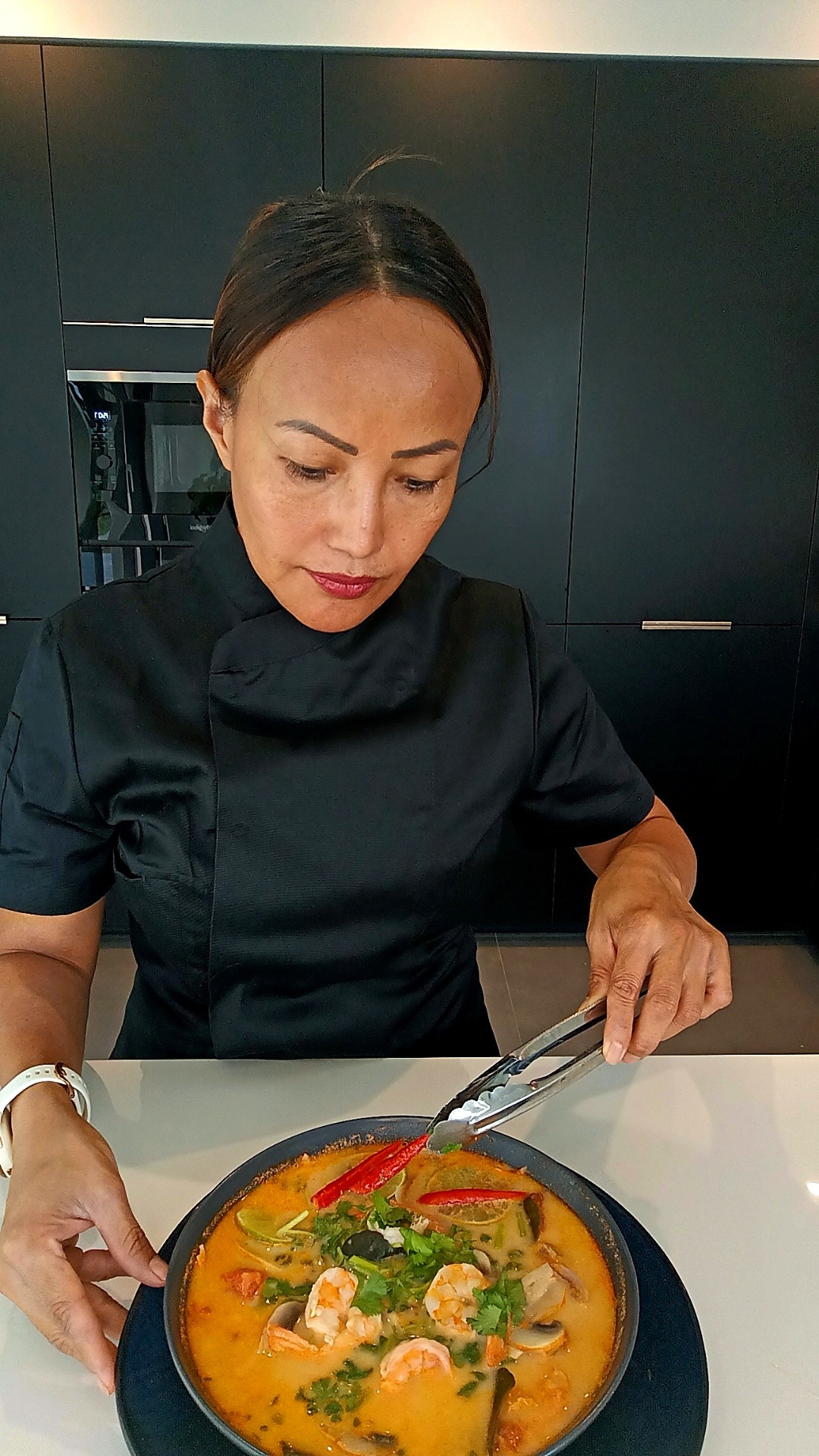 Chef Rinrada plating an authentic tom yum soup